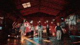 a group of people are dancing in a warehouse with a sign that says gate on it