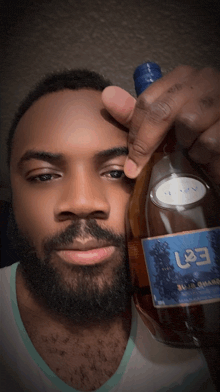 a man with a beard is holding a bottle with a label that says e37 on it