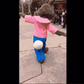 a stuffed animal in a pink shirt and blue pants is dancing