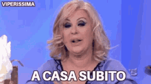 a woman is sitting in front of a blue wall and says immediatemente