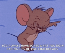 jerry from tom and jerry is laughing while pointing at something .