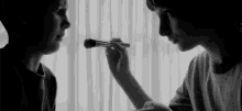 a woman is applying makeup to another woman 's face .