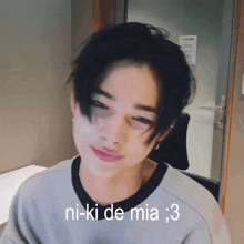 a young man is making a funny face with the words ni-ki de mia : 3 below him