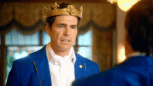 a man in a blue suit is wearing a crown