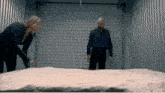 a man and a woman are standing next to a large piece of snow