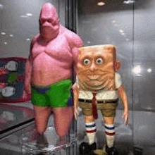 a statue of patrick star and spongebob squarepants are standing next to each other .