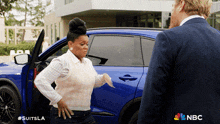 a woman getting out of a blue car with nbc on the bottom right