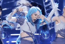 a woman with blue hair is performing on stage