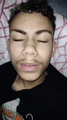 a close up of a young man 's face with his eyes closed .