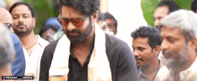 a man wearing sunglasses stands in a crowd with the hashtag pranay_varma at the bottom
