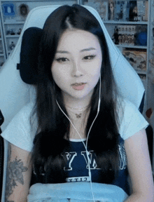 a woman is sitting in a chair wearing headphones and a shirt with the letter y on it .
