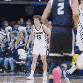 a man in a dawgs jersey stands on the court