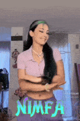 a woman in a purple shirt and purple shorts is dancing in a room with the word nimfa on the bottom