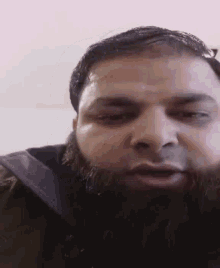 a man with a beard looks at the camera