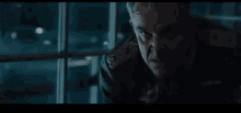 wonder woman is standing in a dark room holding a sword .
