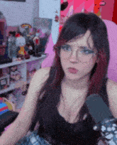 a woman wearing glasses and a black tank top