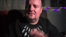 a man wearing a black shirt with lightning bolts on the front