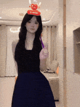 a woman in a black dress is wearing a hat that says ' a ' on it