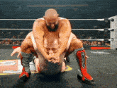 a wrestler wearing a pair of red and black knee pads with the word raw on them