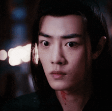 a close up of a young man 's face with a bloody neck