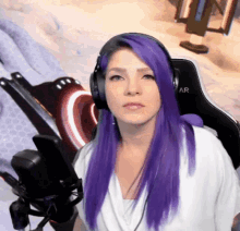 a woman with purple hair is wearing headphones and sitting in a chair that says ar