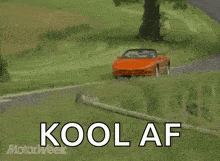 an orange sports car is driving down a road with the words kool af written in white letters
