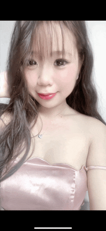 a woman wearing a pink top and a heart necklace
