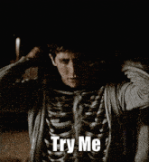 a man wearing a skeleton shirt with the words " try me " on it