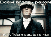 a man in a suit and hat is standing in front of a sign that says " всем встать раком "