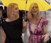 two women are holding an umbrella in the rain