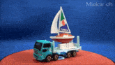 a toy truck is carrying a boat with the word tomica on it