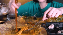 a woman is eating noodles with chopsticks from a bowl