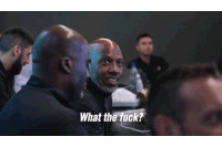 a group of men are sitting around a table and one man says what the fuck