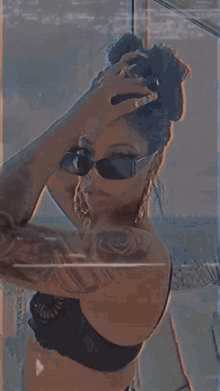 a woman in a bra and sunglasses is taking a picture of herself