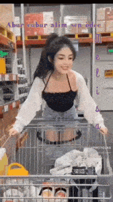 a woman is pushing a shopping cart in a store with the words " abur cubur alim sen odee " on the bottom