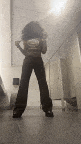 a woman is standing in a public restroom wearing a crop top that says california