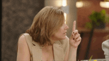 a woman holds her finger up to her lips