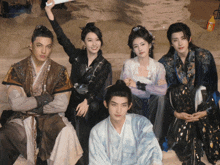 a group of people are posing for a picture and one of them is holding a fan