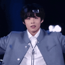 a young man wearing a blue jacket and white shirt with a black tie