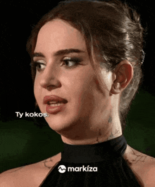 a close up of a woman 's face with the words ty kokos on the bottom right