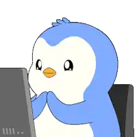 a blue and white penguin sitting in front of a computer monitor
