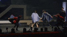 a group of people dancing on a stage with a sign that says nikon