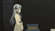a girl stands next to a laney amplifier in a dark room