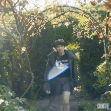 a woman wearing a t-shirt that says " adulton " is walking through a forest