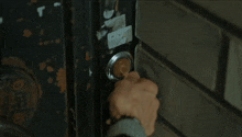 a close up of a person 's hand opening a door with a sticker on it that says ' a ' on it