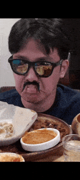 a man wearing sunglasses and a fake mustache looks at food