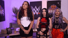 three women are standing in front of a sign that says halloween