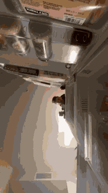the inside of a refrigerator with a kirkland item in the door