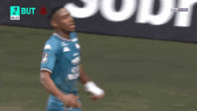 a soccer player in a blue shirt is celebrating a goal in front of a sign that says cheval