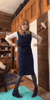 a woman in a blue dress and black boots is dancing